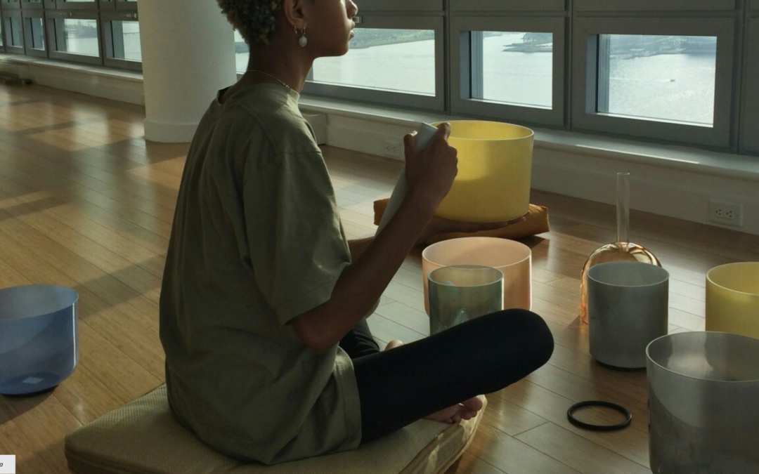 girl sitting with singing bowls for healing frequencies